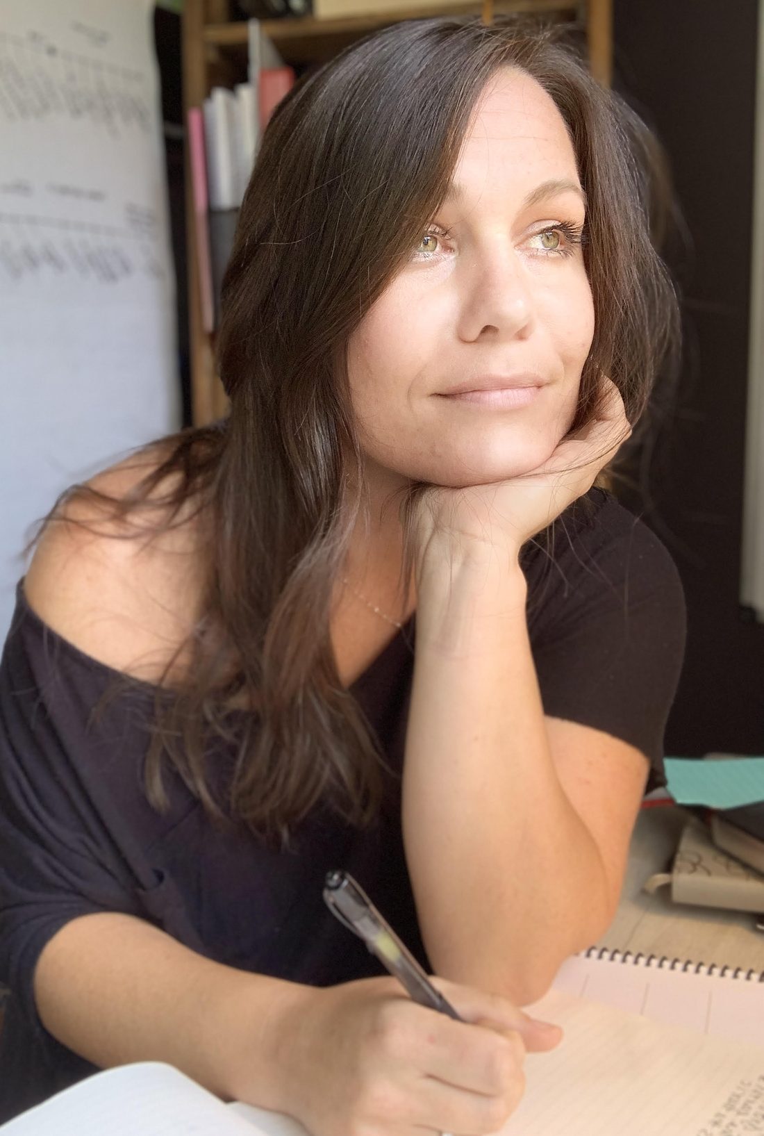 Portrait of Caity Surface at her desk with notebooks and charts